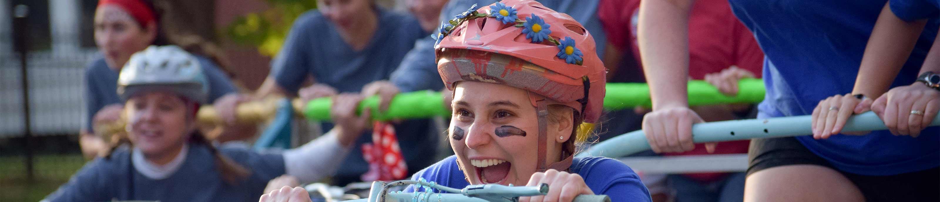 Student having fun riding in a bed at bed races